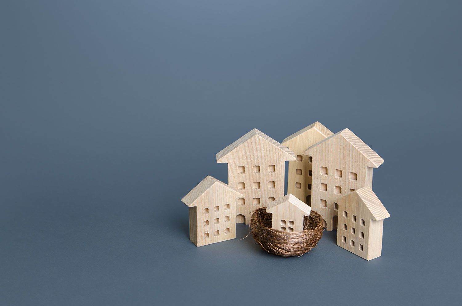 Individuals holding small umbrellas and model homes, housing ins Seguro comunidades de propietarios